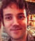 A profile of a smiling man with brown hair.